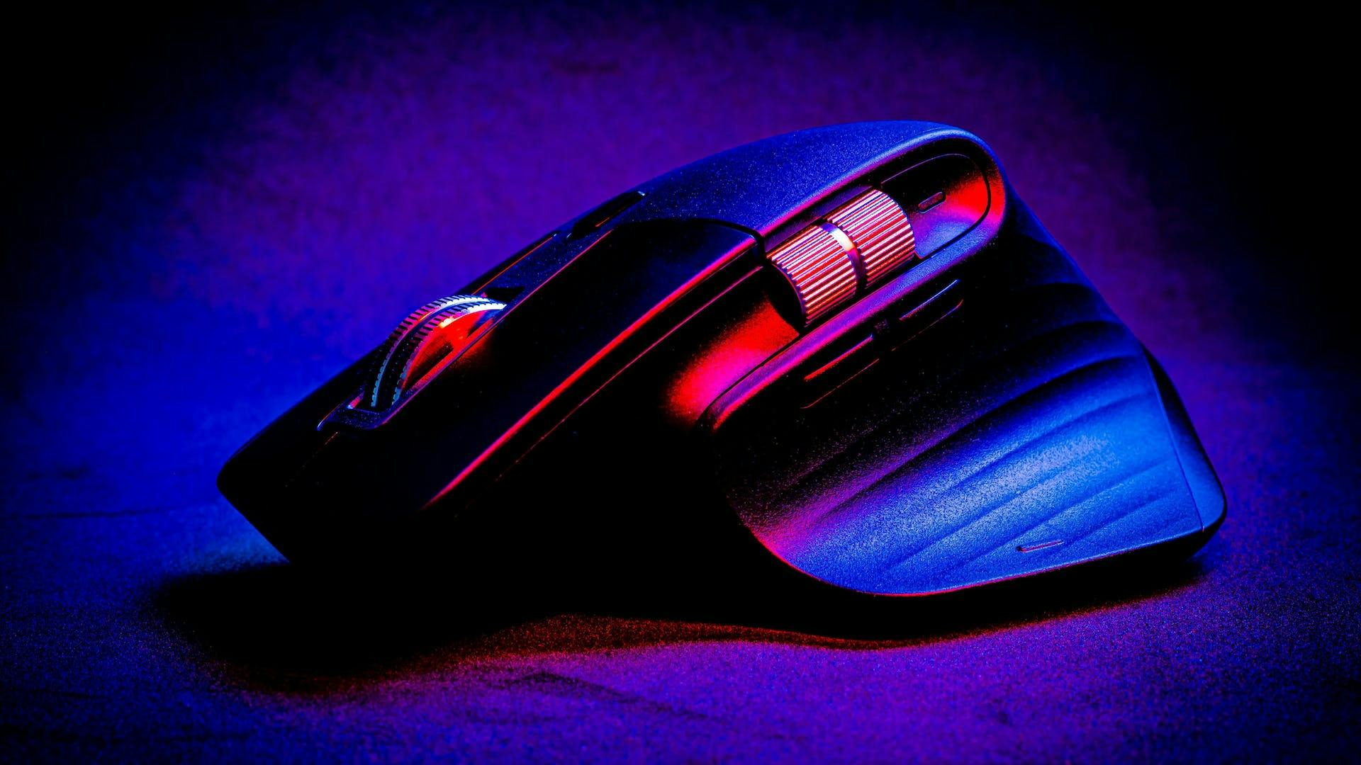 A red and blue glowing, wireless and unusually shaped LED gaming mouse with mouse wheels on the side