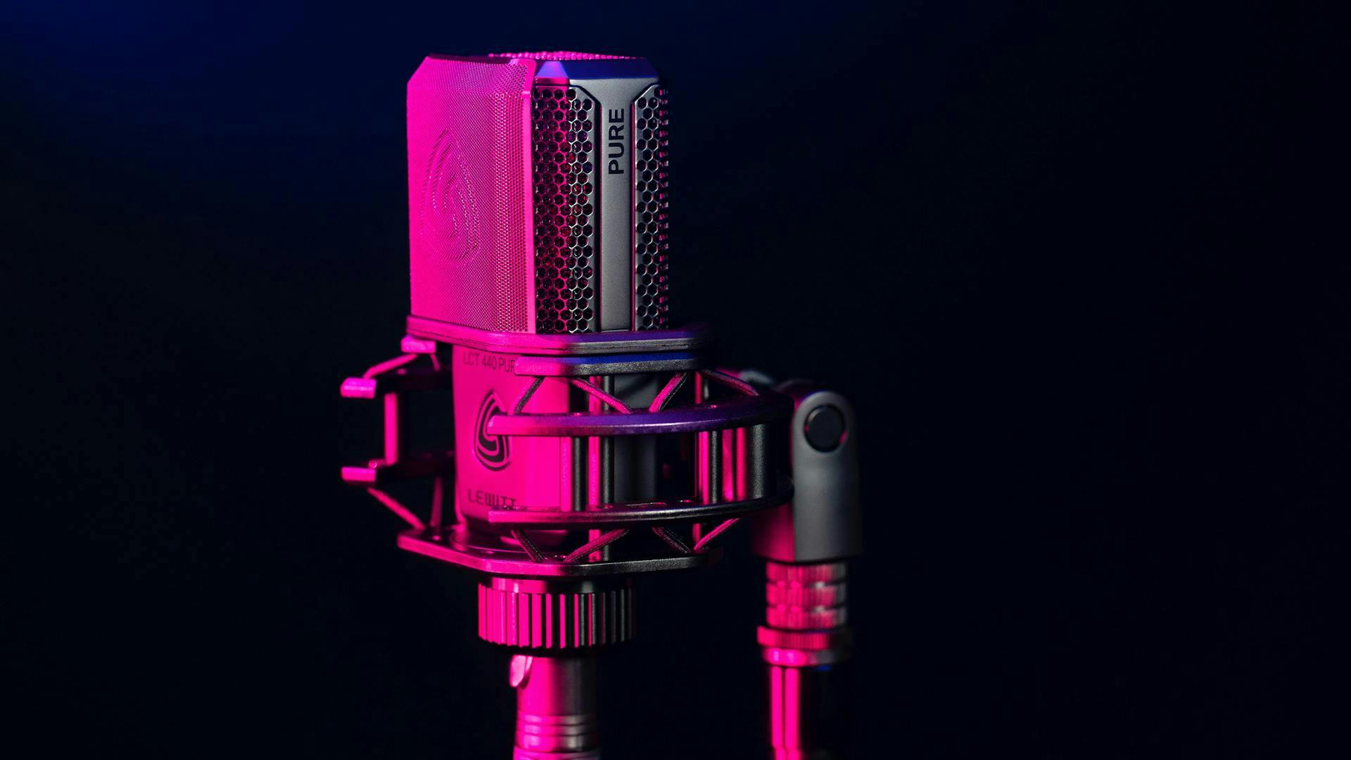 Ein durch rosa Licht hell erleuchtetes Standmikrofon