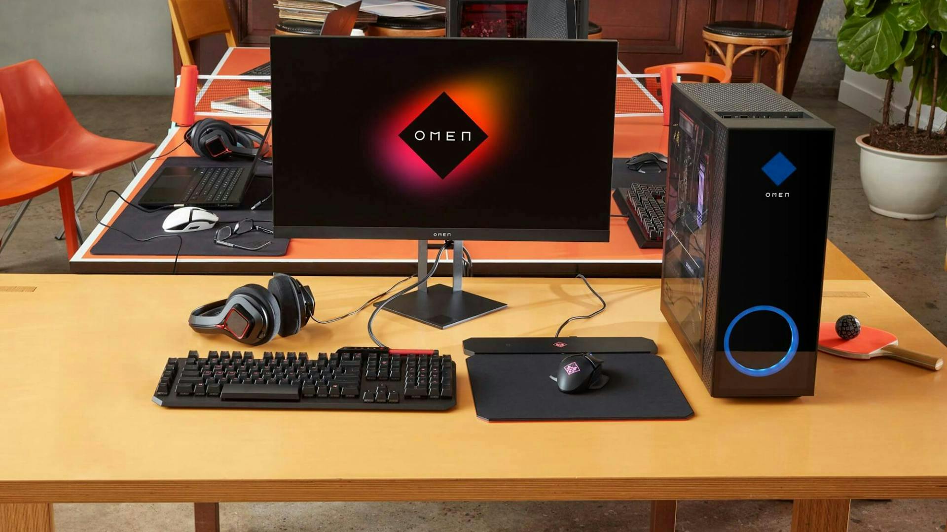 Auf einem Tisch steht ein Gaming PC mit Gaming Setup Zubehör wie Maus, Tastatur, Monitor und Headset 