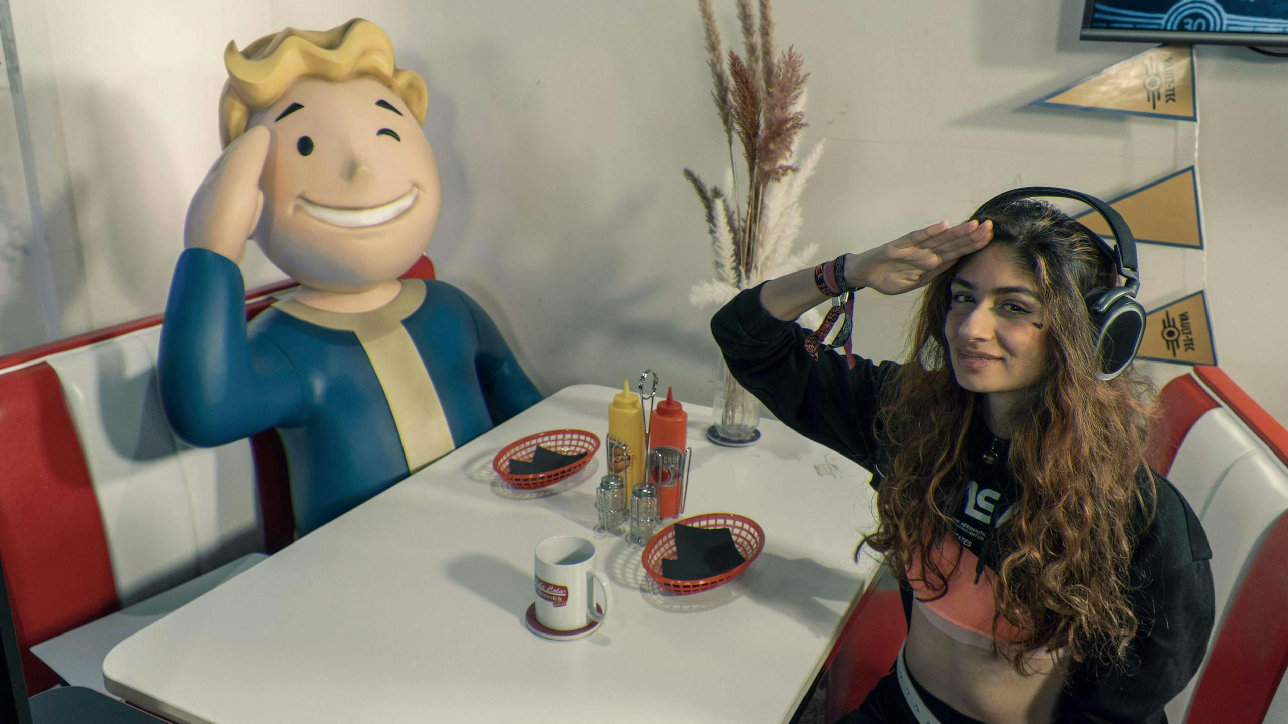 Gaming Setup fallout style: Vault Boy und Gamer girl salutieren