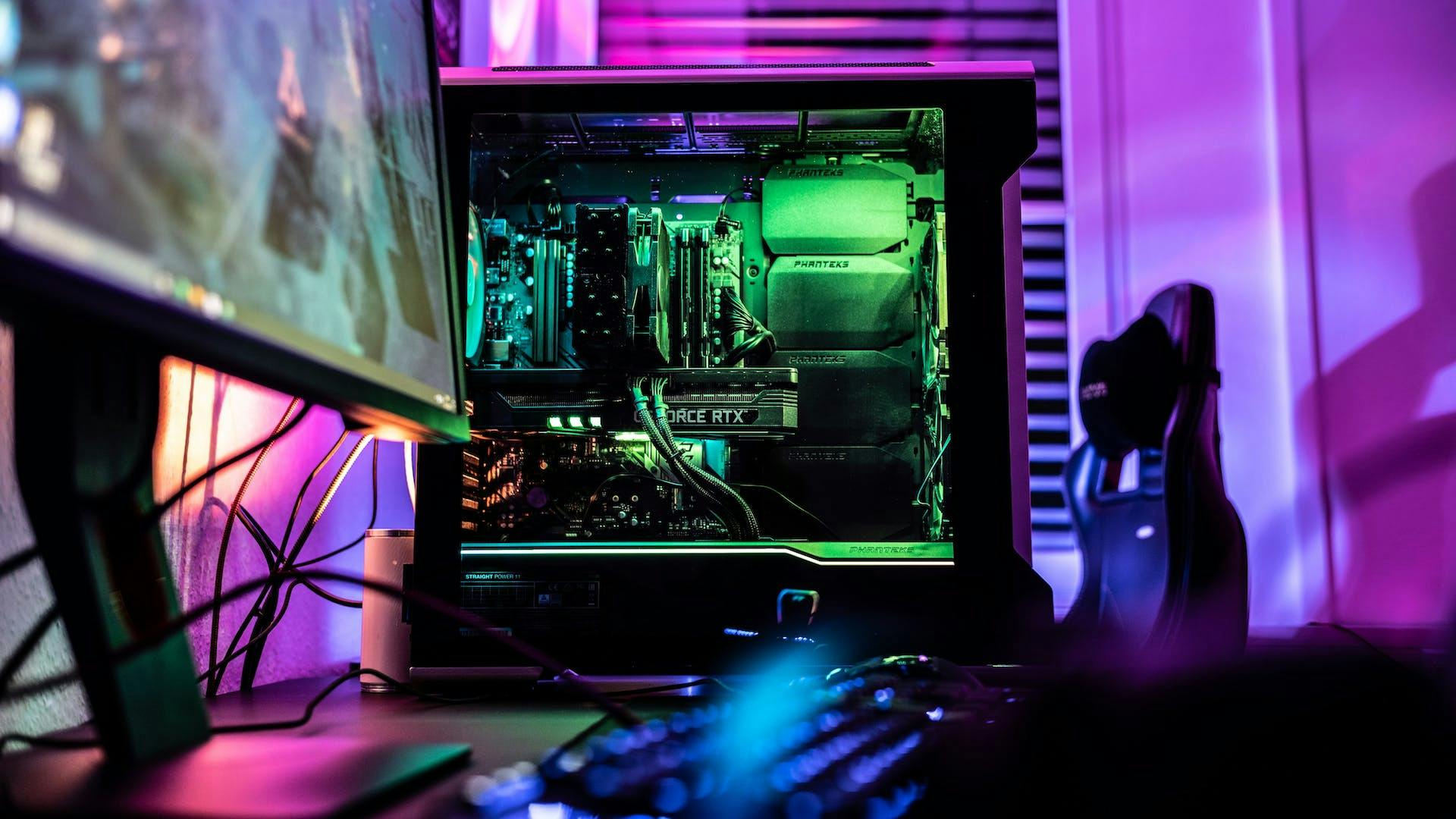 In einem bunt leuchtenden RGB Setup steht ein beleuchteter RGB Streaming PC