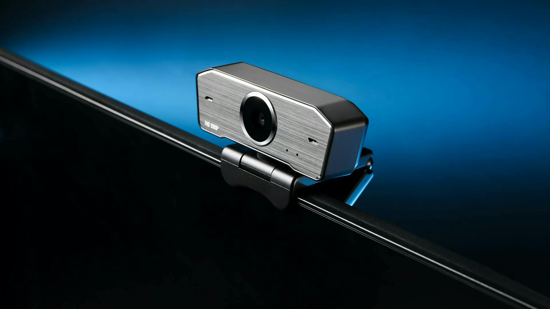 Eine kleine silberne Streaming Webcam ist auf einem PC Bildschirm befestigt.