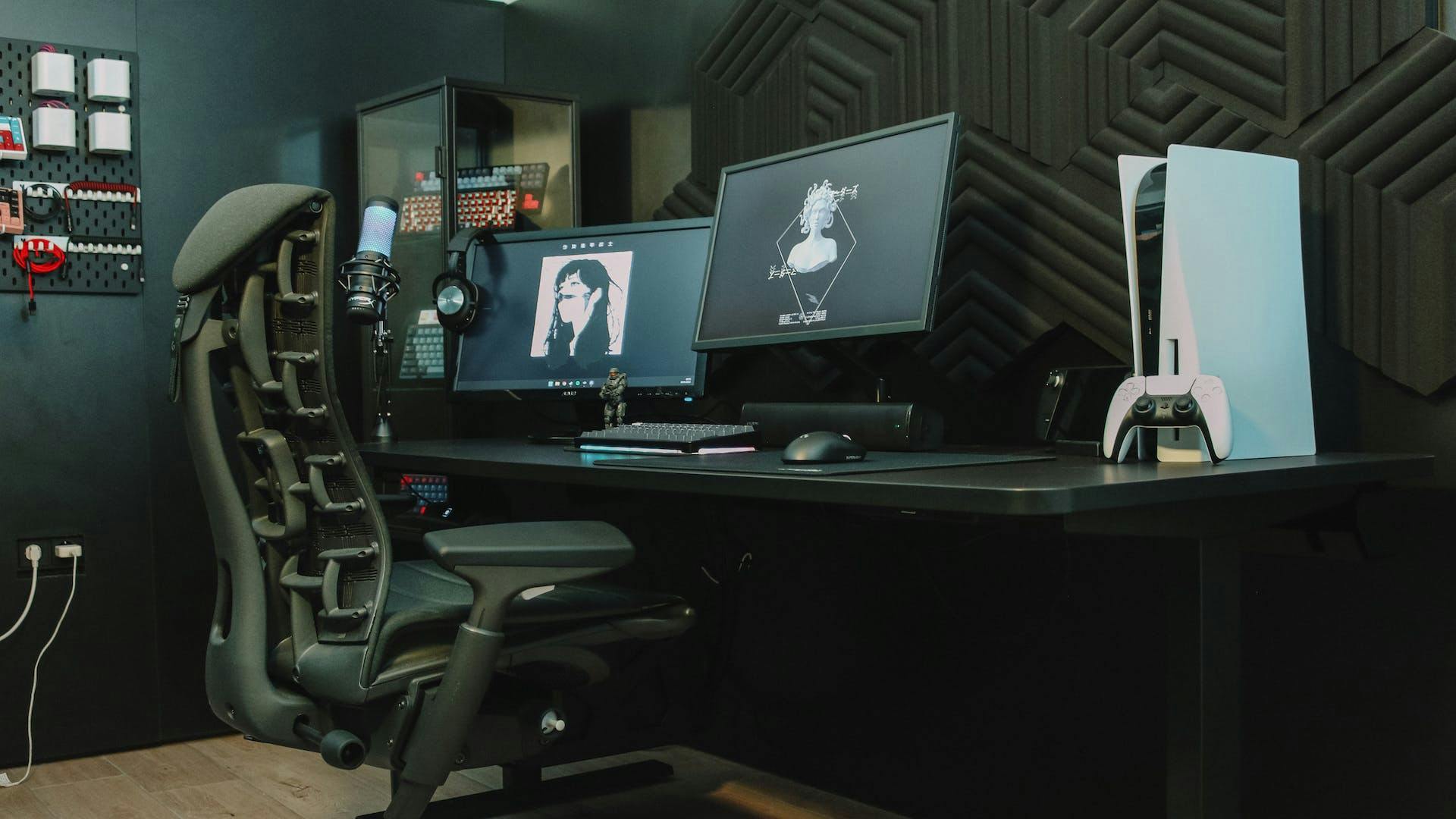 In einem dunkel gehaltenen Gaming Setup mit blauen Neon-Akzenten sitzt eine Person vor einem schwarzen Gaming PC und Playstation