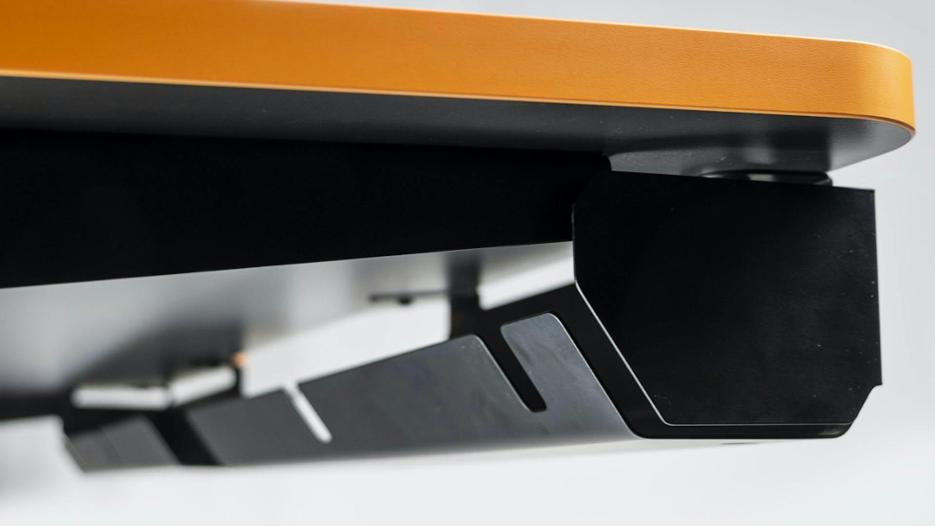 Nahansicht unter eine Tischplatte des höhenverstellbaren Gaming Tisch von LeetDesk, unter der eine LeetDesk Kabelschiene angebracht ist 